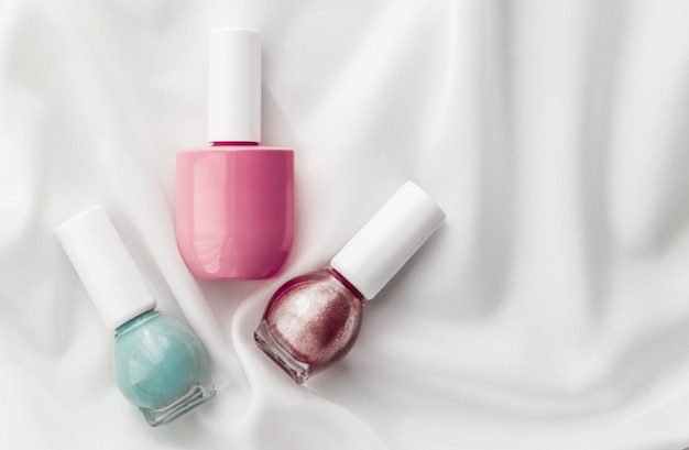 Bouteilles de vernis à ongles sur fond de soie produits de manucure français et cosmétiques de maquillage de vernis à ongles pour la marque de beauté de luxe et la conception d'art flatlay de vacances