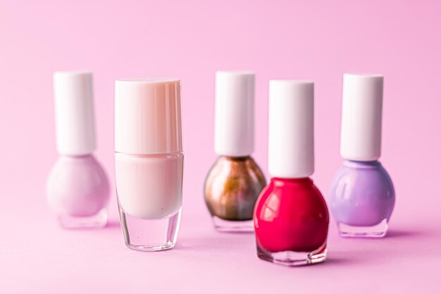 Bouteilles de vernis à ongles sur la marque de beauté de fond rose