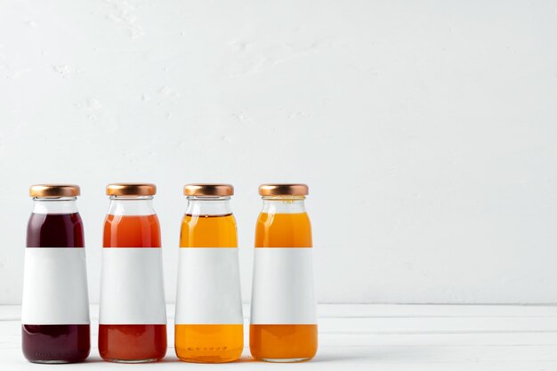Photo bouteilles en verre de différents jus sur fond blanc