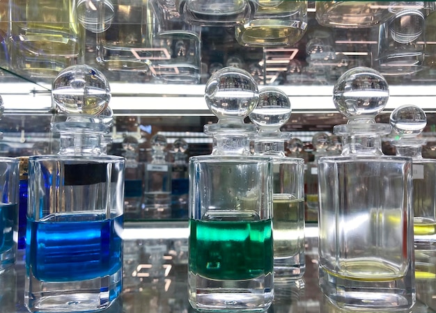 Photo des bouteilles de verre avec du parfum sur une étagère en verre