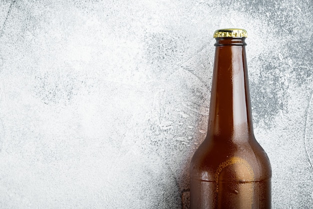 Bouteilles en verre de jeu de bière, sur une table en pierre grise, vue de dessus à plat