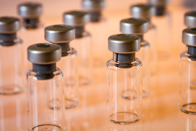 Photo bouteilles en verre de vaccin sur orange