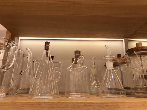 Bouteilles en verre de vaisselle de différentes formes sur la vitrine