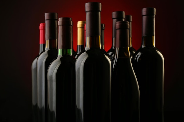 Bouteilles de vin d'affilée sur fond rouge foncé se bouchent