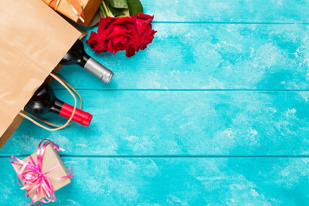 Bouteilles de vin et fleurs roses sur table en bois