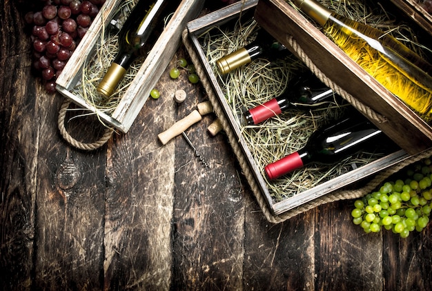 Bouteilles de vin rouge et blanc dans de vieilles boîtes