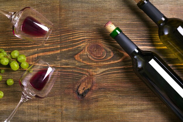 Bouteilles de vin rouge et blanc raisin et verres sur table en bois vue de dessus avec espace de copie