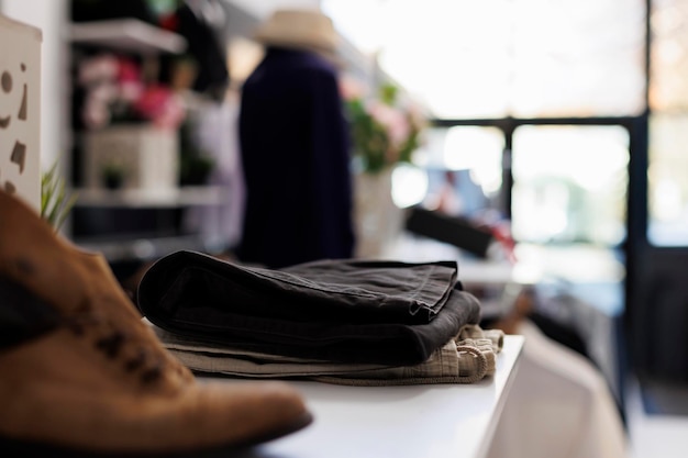 Boutique moderne vide dans le centre commercial, nouvelle collection de mode sur étagère. Vêtements à la mode sur cintres élégants et accessoires, magasin de vêtements avec des marchandises en vente pour les clients