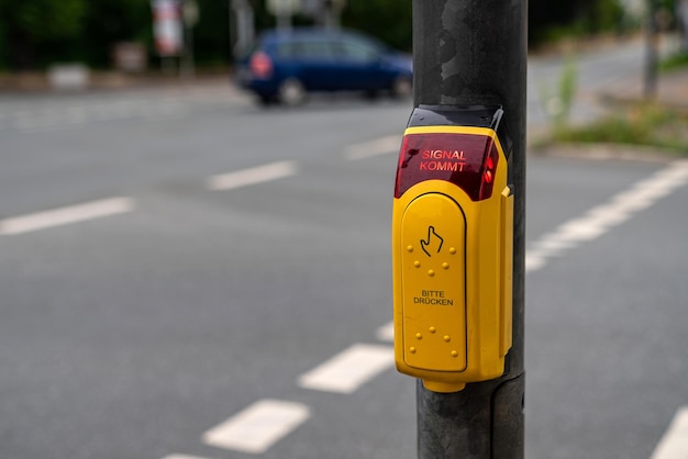 Bouton de passage pour piétons avec rue floue avec voiture