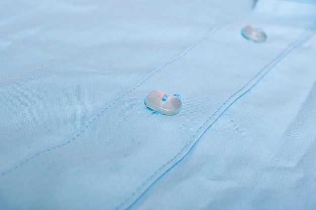 Boutons sur une chemise bleue se bouchent