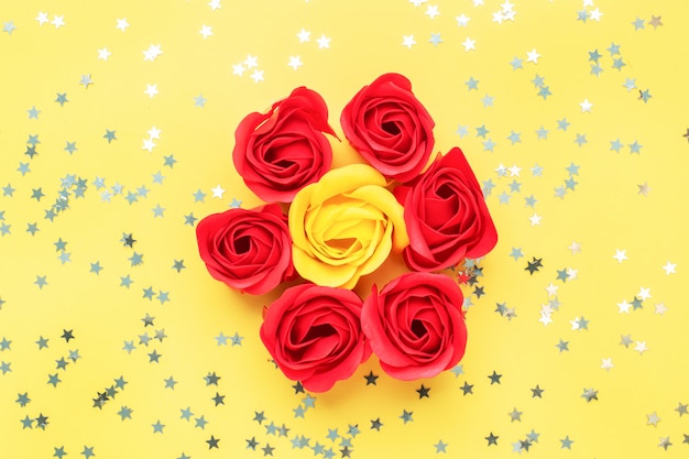 Boutons de roses rouges et jaunes sur fond jaune. Le concept de la Saint-Valentin, la romance de mariage. Mise à plat Espace copie.
