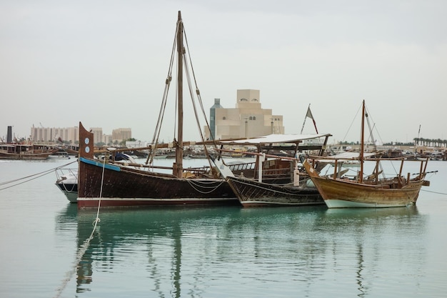 Boutres arabes traditionnels sur la mer avec derrière les toits de la ville