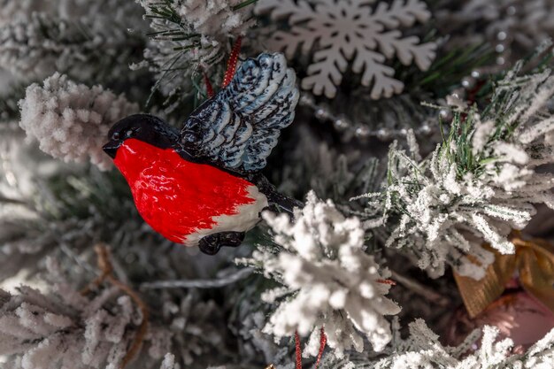 Bouvreuil jouet du Nouvel An sur un arbre de Noël décoré Traditions et vacances Gros plan