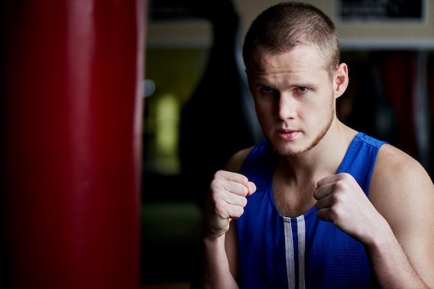 Boxe. Portrait d'un boxeur sur le fond de la salle de sport