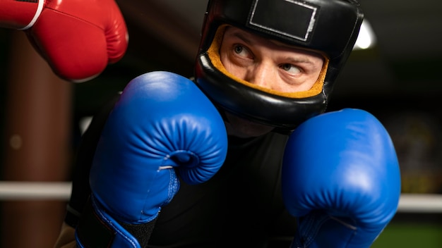 Boxer avec casque et gants de formation dans le ring