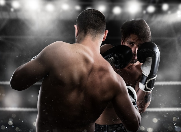 Photo boxer dans une compétition de boxe bat son adversaire avec un coup de poing