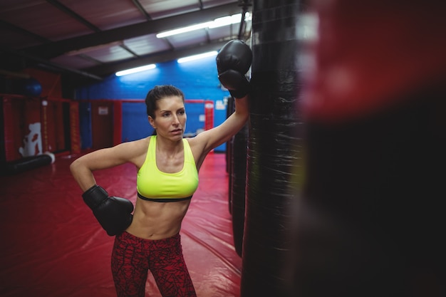 Boxer féminin s'appuyant sur un sac de boxe