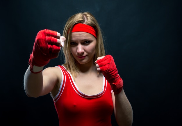 Boxer femme en bandages de boxe rouges et vêtements de sport