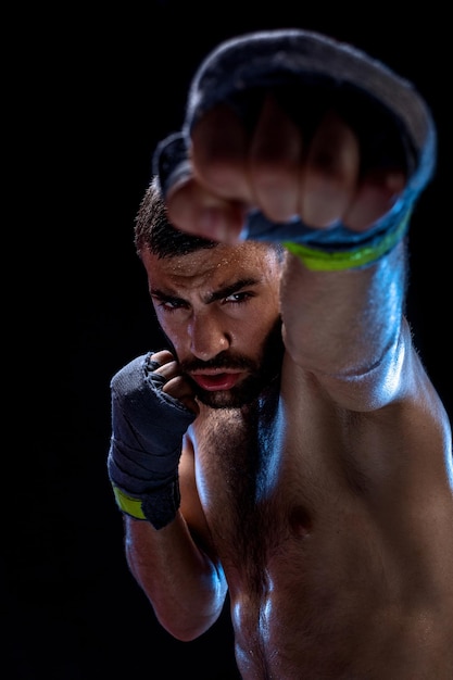 Le boxeur est prêt à donner un coup puissant photo d'un homme musclé aux mains fortes et au poing fermé...