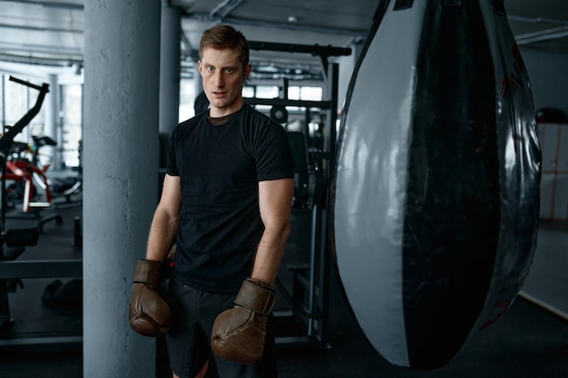 Photo boxeur fatigué avec corps masculin dans des gants de boxe