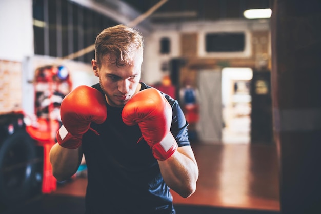 Un boxeur s'entraîne à la boxe avec un sac de punch dans un gymnase.