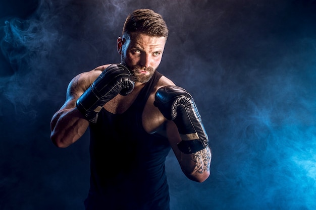 Boxeur sportif combattant sur un mur noir avec une ombre. Copiez l'espace. Concept de sport de boxe.