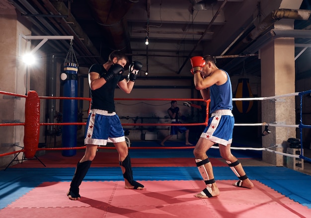 Les boxeurs s'entraînent au kickboxing sur le ring au club de santé