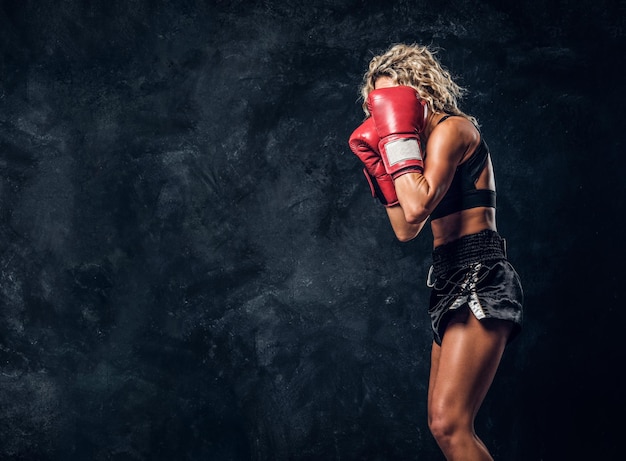 La boxeuse blonde expérimentée fait la démonstration de son attaque tactique avec des gants spéciaux.