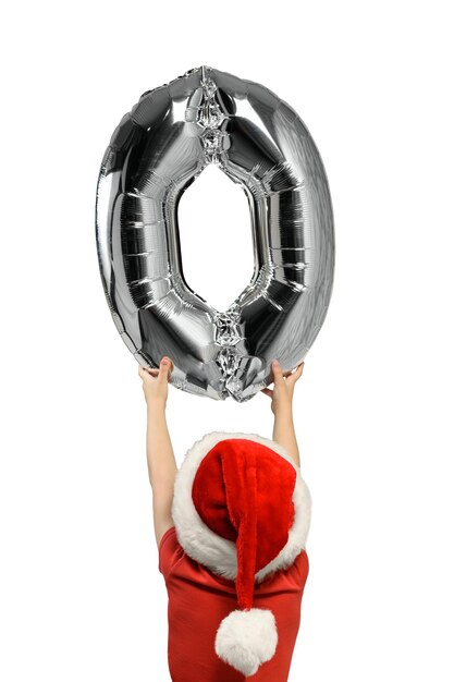 Boy in Santa hat contient jusqu'à chiffre zéro gonflable argent Vue arrière isolé sur fond blanc