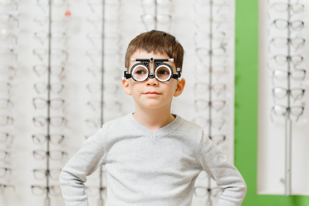 Boy a mis le cadre d'essai au concept de clinique d'opticien médical.