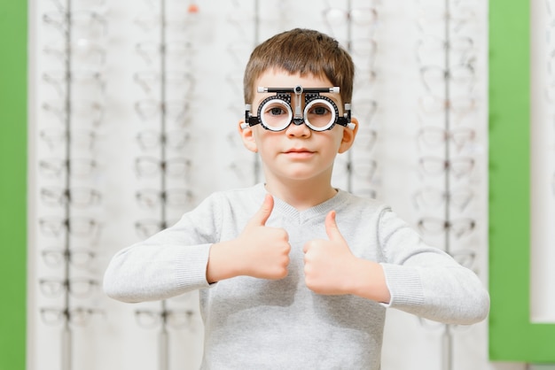 Boy a mis le cadre d'essai au concept de clinique d'opticien médical.