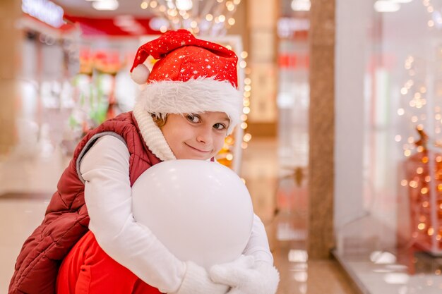 Boys in santas hat se penche sur le magasin par la fenêtre du marché