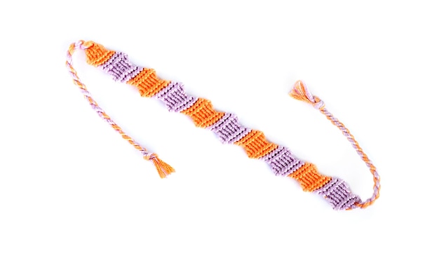 Bracelet d'amitié tissé violet et orange bricolage avec tressage inhabituel isolé sur fond blanc