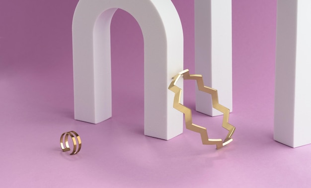 Bracelet et bague dorés en forme de zigzag sur arche blanche et colonnes sur fond violet