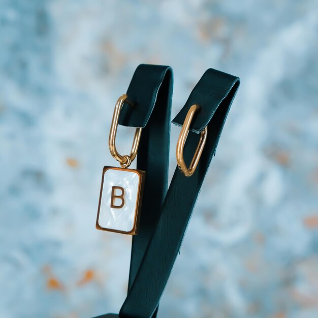 Un bracelet en cuir noir avec la lettre b dessus