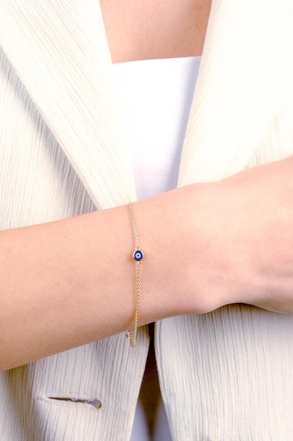 un bracelet avec une épingle bleue est sur le poignet d'une femme