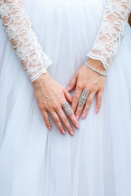 Bracelet de joaillier et bagues sur la main de la mariée