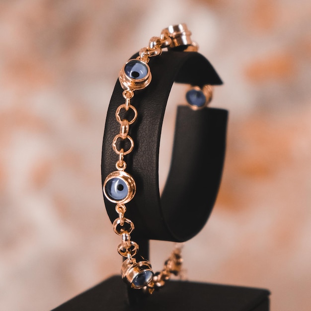 Un bracelet noir avec des perles bleues et dorées et un bracelet noir.