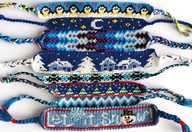 Bracelets d'amitié bricolage tissés à la main de fil brillant de broderie avec des noeuds sur blanc