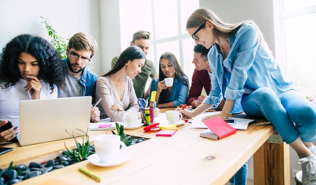 Brainstorming dans le bureau de démarrage. Une jeune équipe d'affaires moderne et gaie travaille sur un projet important