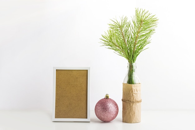 Branche d'arbre de Noël, cadre blanc et boule rose