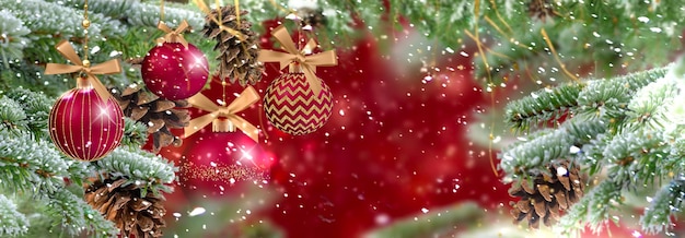 Branche d'arbre de pin vert de Noël avec cône et boule rouge sur les flocons de neige festifs d'hiver floue gol