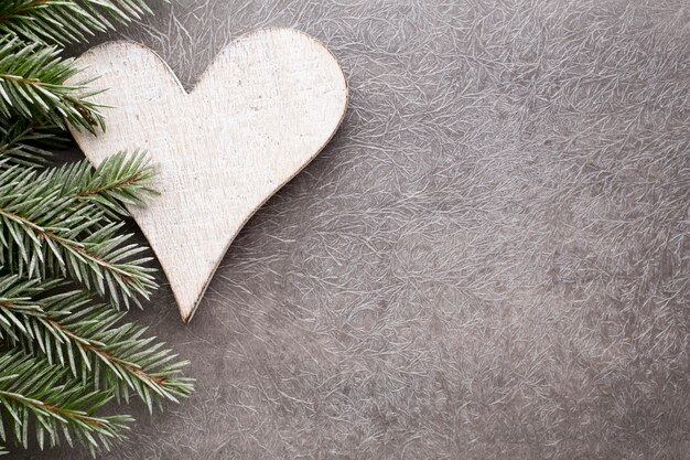 Branche d'épinette avec des décorations de Noël sur fond gris.