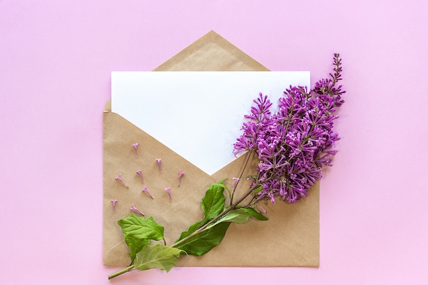 Branche de lilas sur enveloppe artisanale avec carte vide