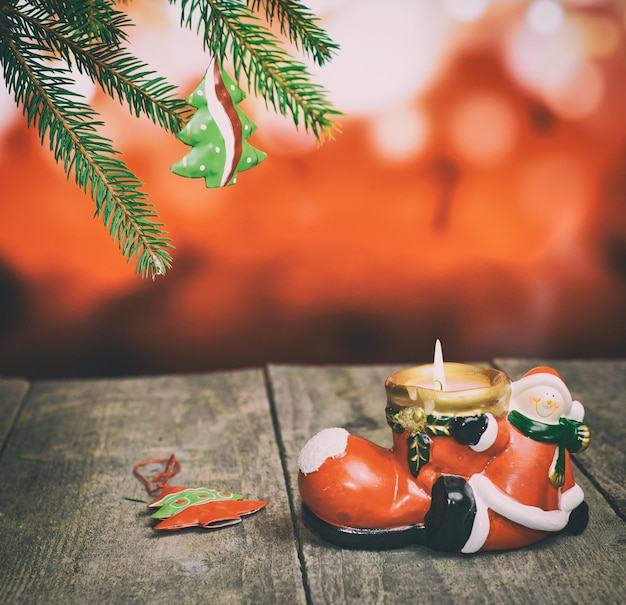 Photo branche de pin avec porte-bougie en céramique de jouet d'arbre de noël sur la vieille table en bois