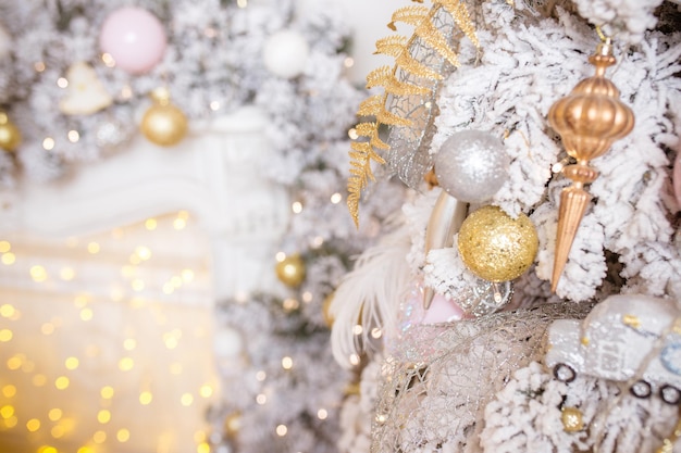 Branche de sapin avec des boules d'or et des lumières festives sur le fond de Noël avec des étincelles