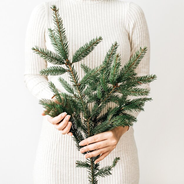 Branche de sapin dans la main féminine.