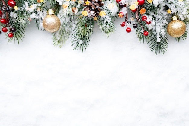 Branche de sapin avec des décorations de Noël sur fond de neige naturelle