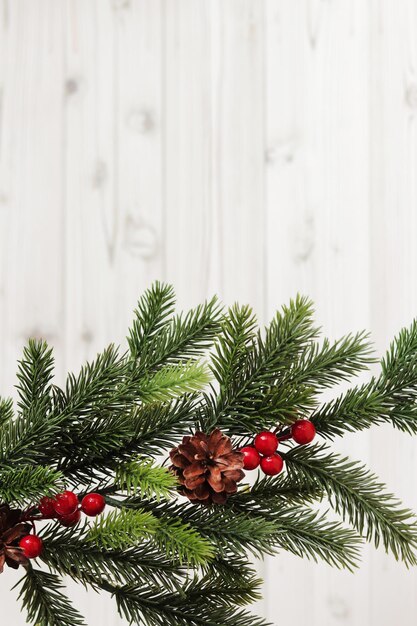 Branche de sapin de Noël avec décor et cône de pin sur un espace de copie de fond en bois clair