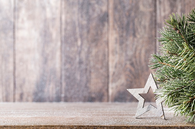 Branche de sapin de Noël et décor, sur le fond en bois.